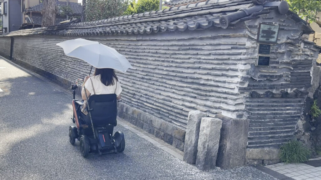 土と瓦が交互に積み重なった、趣ある辻塀の横を通るmonさま